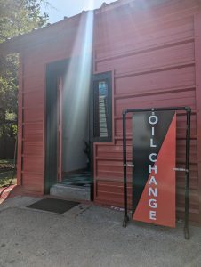 a red building with a red and black sign reading "oil change"