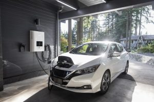 A white electric car charging in a garage.
